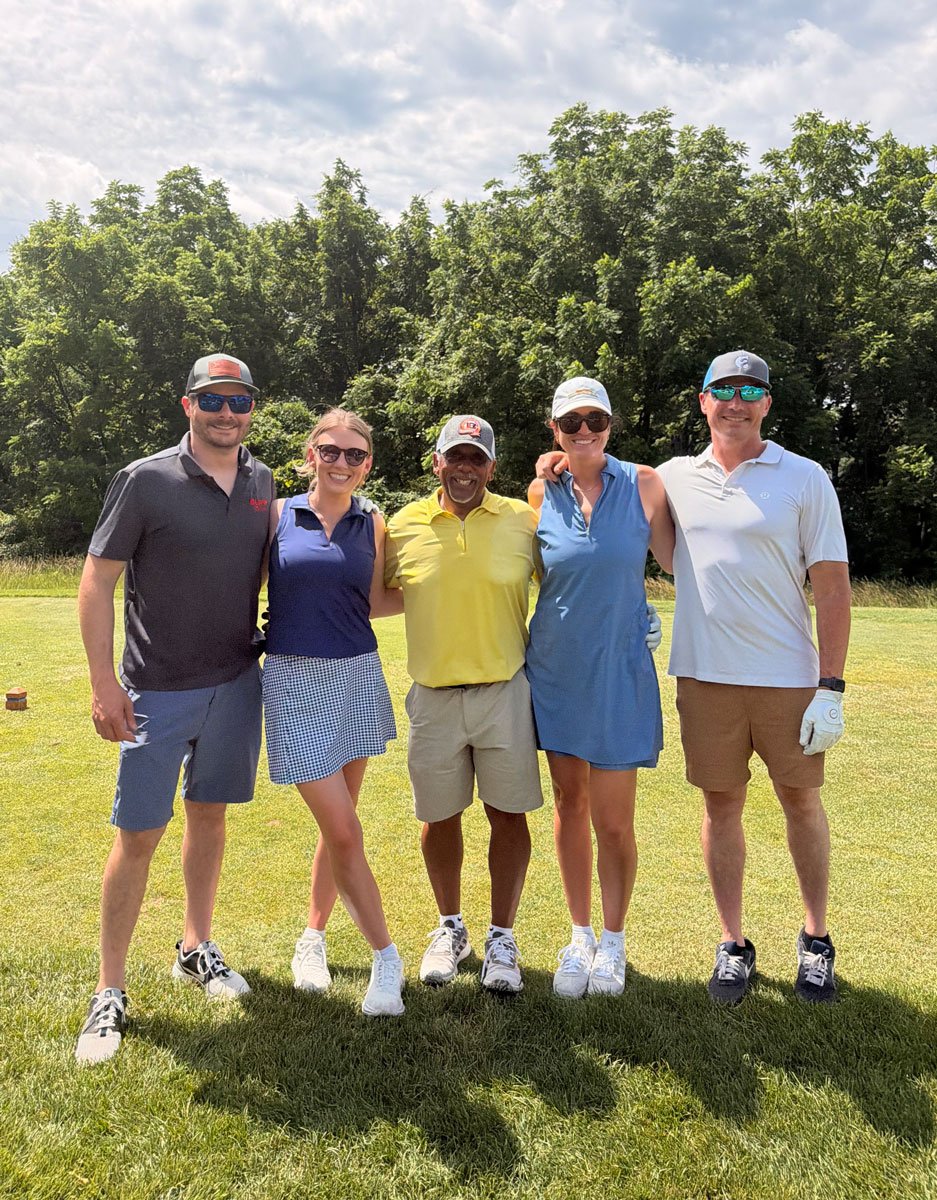Five Ample team members arm in arm on a golf course
